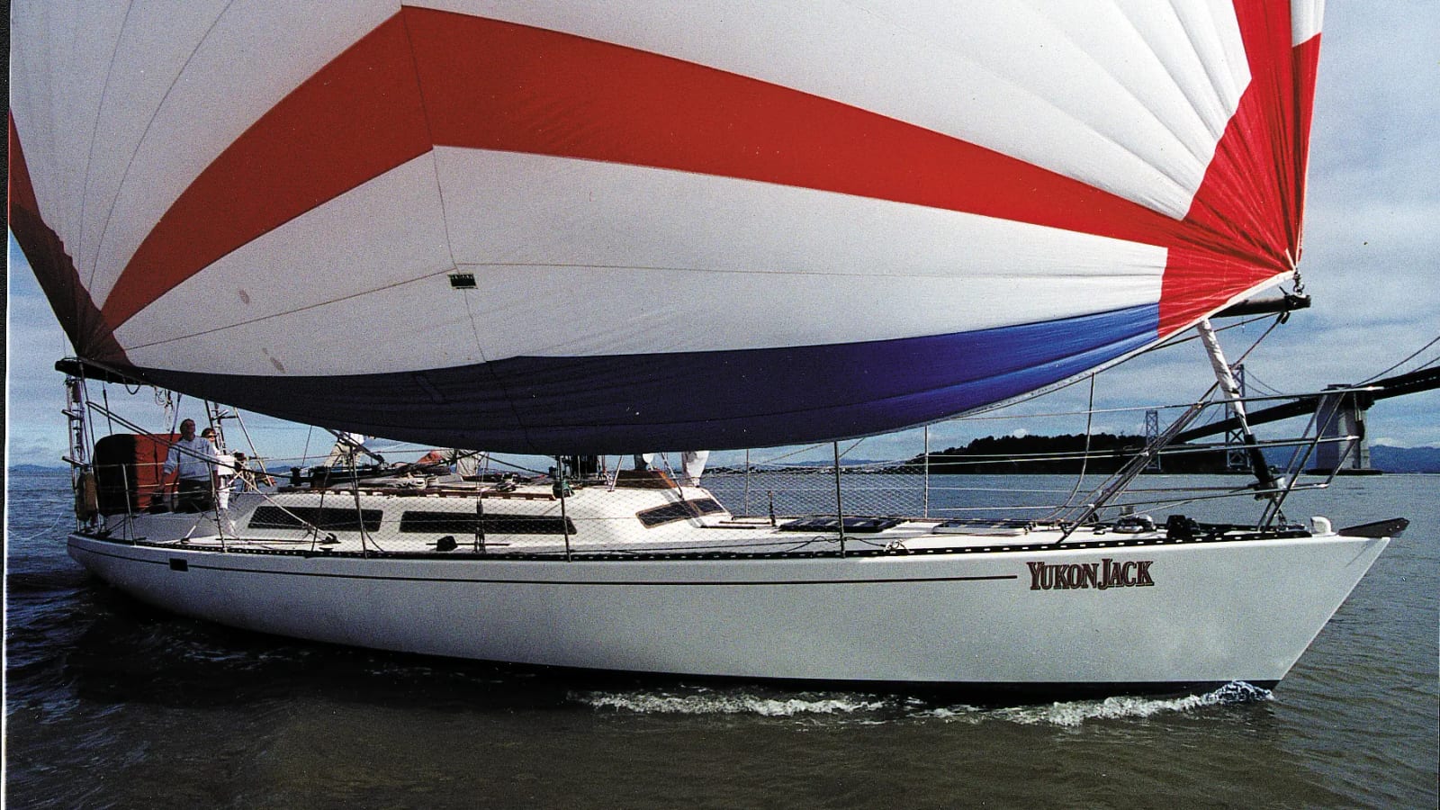 Yukon Jack sailing under a large red and white spinnaker on San Francisco Bay